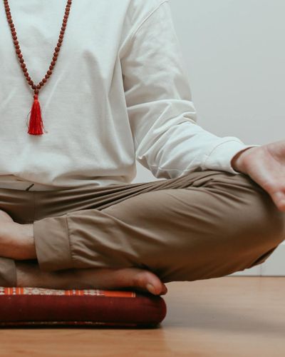 Close-up of a person's hands in a meditative gesture.